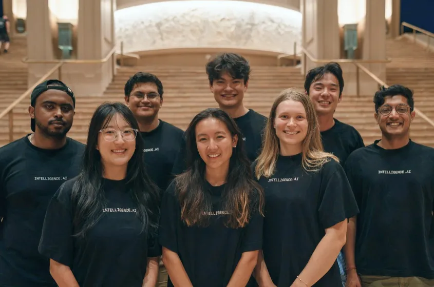 The team in matching Intelligence.ai shirts posing on a grand staircase
